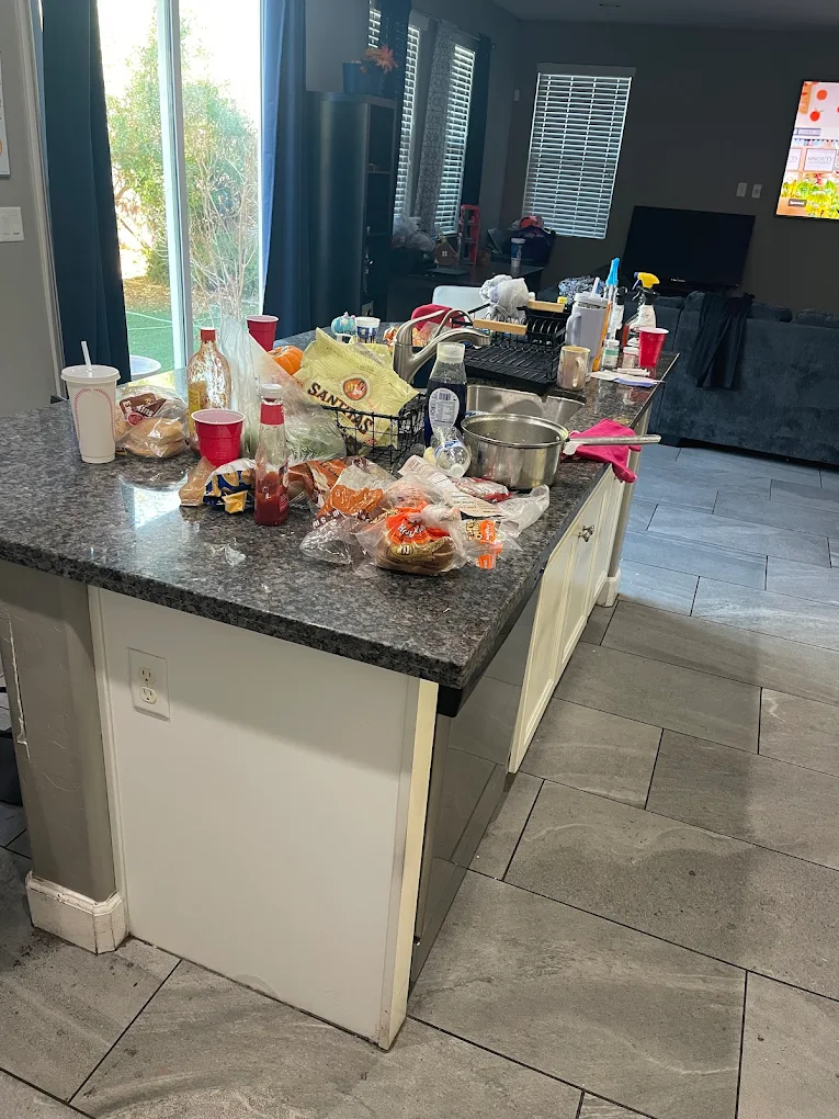 Before cleaning: kitchen counters and sink area with visible clutter and buildup